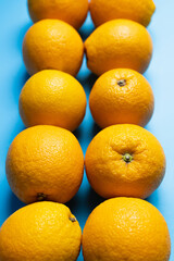 Close up view of ripe oranges on blue background.