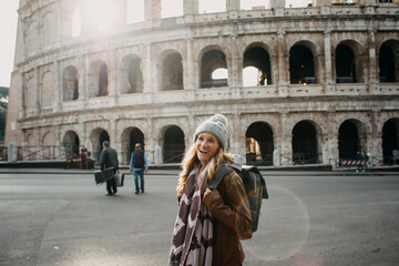 Happy Female Tourist at Colosseum in Rome. Smiling Solo Traveler Exploring Historic Landmark in...