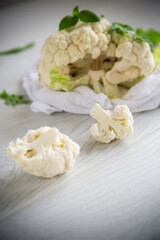 inflorescences of small cauliflower on a light wooden table