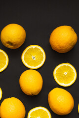 Top view of whole and slices of oranges isolated on black.