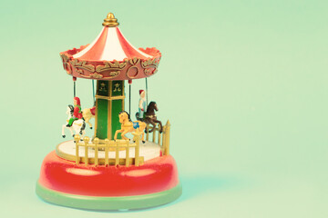 Vintage toy carousel on an emerald background. Red carillon with carousel, retro carousel