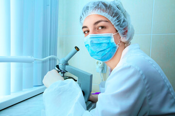 Laboratory assistant in a hospital with a microscope. A professional woman scientist is working on a vaccine in a research laboratory. Workplace of a genetic engineer. Technology and science concept.