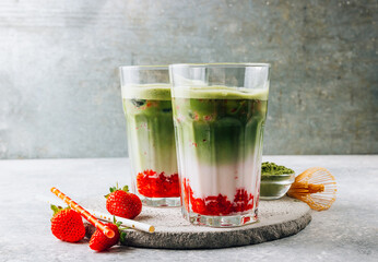 Summer strawberry matcha latte with ice in a glass cup