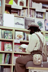 Asian women reading book by bookshelf in bookstore. Hobbies, leisure and education concept.