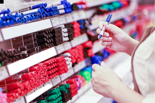 Close up woman hand choosing a pen in stationery store.