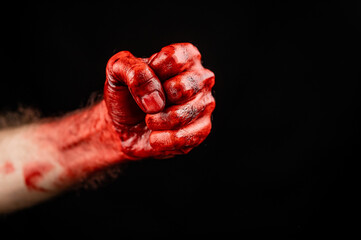 Bloody male fist on a black background. Copy space. 