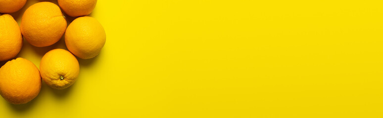 Top view of sweet oranges with shadow on yellow surface, banner.