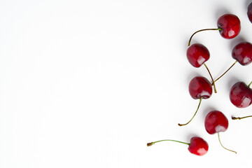 Sweet red cherries isolated on white background, fresh cherries with stems and leaves. Copy space. Food and fruit concept.