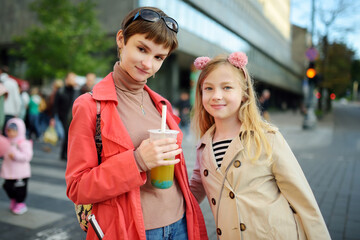 Two cute young sisters having fun together on beautiful autumn day. Active family leisure with kids.