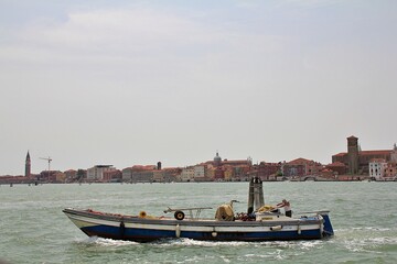 fishing boat in the background city of Chioggia, boat on the sea and city in the background, Italian fishing town, orange-red buildings, Italy, fisherman