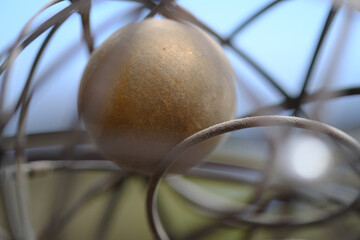 Closeup shots of brass and wire sphere with ball inside