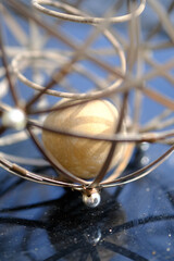 Fototapeta na wymiar Closeup shots of brass and wire sphere with ball inside