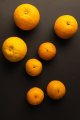 Top view of bright citrus fruits on black background.