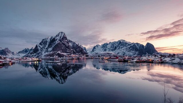 Traditional fishing village in scandinavian on coastline with mountain range reflection on arctic ocean in the morning on winter at Reine town, Lofoten Islands, Norway