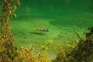 Clear river Dawki in Meghalaya India with a person sitting on a boat