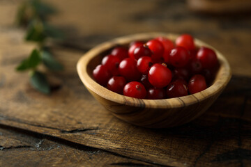 Fresh ripe cranberry in a wooden bowl