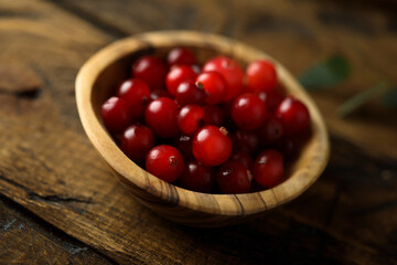 Fresh ripe cranberry in a wooden bowl