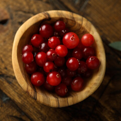 Fresh ripe cranberry in a wooden bowl