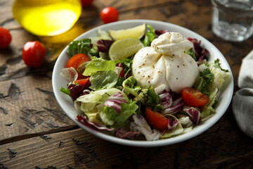 Healthy green salad with tomato and burrata cheese