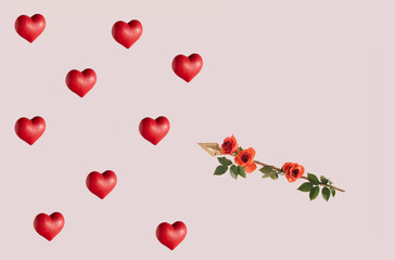 Red hearts and one golden arrows, creative floral pattern on pastel pink background. Romantic love and passion concept. 