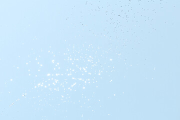 Sparkling silver glitter on blue background. Holiday blurred lights
