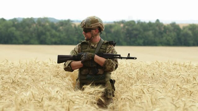 Close up of Soldier man in full outfit walking in the field. Portrait of a happy soldier in a boot camp. US Army soldier in the Mission. war and emotional concept.