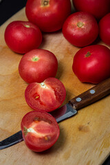 Tomatoes on a cutting board on a black background. Cooking food from tomato.