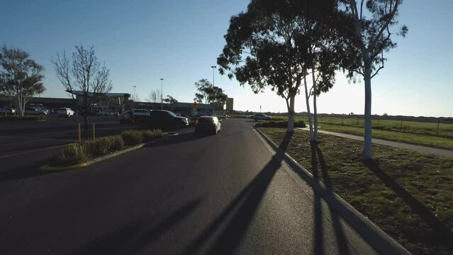 A running shot of a beautiful road where cars are seen moving alongside of the road in sunny weather