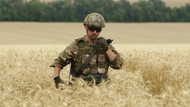 Close up of Soldier man in full outfit walking in the field. Portrait of a happy soldier in a boot camp. US Army soldier in the Mission. war and emotional concept.