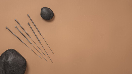 3D rendering of acupuncture needles and stones on a brown surface - obrazy, fototapety, plakaty