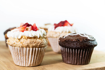 Cupcake with white icing chocolate filling with strawberries on white background