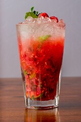 Vertical closeup of Raspberry mojito on wooden table