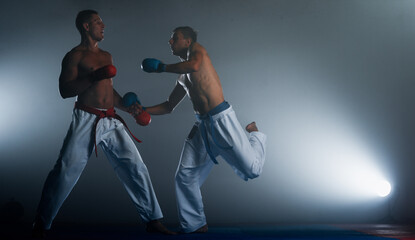 Karate martial arts fighters in white kimono in the gym