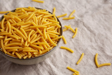 Dry Organic Maccheroni Pasta in a Bowl, side view. Space for text.
