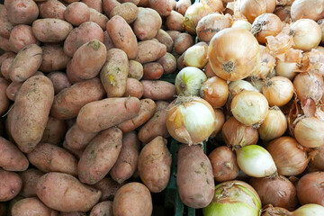 Potatoes and onions on counter of the store.