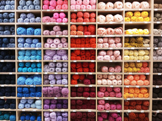 Skeins of yarn on  wooden rack on the store counter.