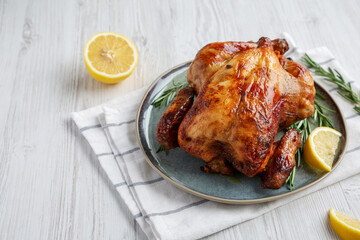 Homemade Lemon and Herb Rotisserie Chicken on a Plate, low angle view. Copy space.