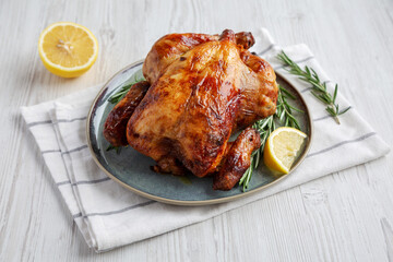 Homemade Lemon and Herb Rotisserie Chicken on a Plate, side view.