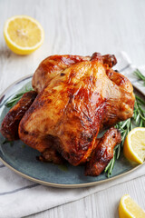 Homemade Lemon and Herb Rotisserie Chicken on a Plate, side view.