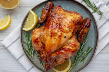 Homemade Lemon and Herb Rotisserie Chicken on a Plate, top view. Flat lay, overhead, from above.