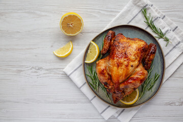 Homemade Lemon and Herb Rotisserie Chicken on a Plate, top view. Flat lay, overhead, from above....