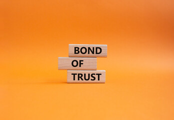 Bond of trust symbol. Wooden blocks with words Bond of trust. Beautiful orange background. Business and Bond of trust concept. Copy space.