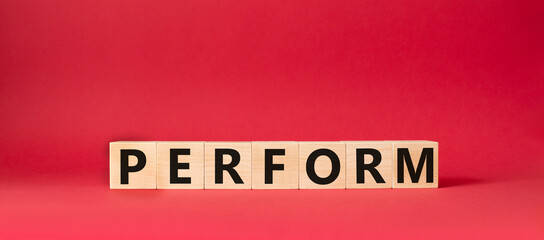 Perform symbol. Concept word Perform on wooden cubes. Beautiful red background. Business and Perform concept. Copy space.