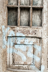 part of an old door with peeling paint and blue stripes, front view