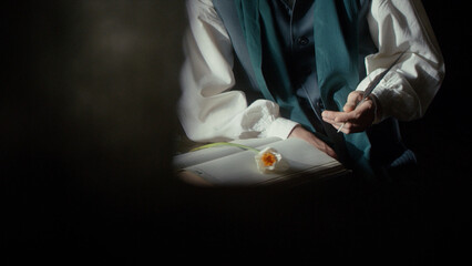 A male perfumer writer with a pen in his hands prepares to write down a recipe for a new fragrance. Medieval style. Cinematic concept