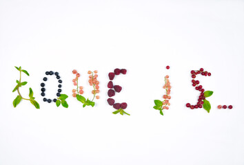  Words '' love is '' made from fresh summer berries and green mint leaves on white background. Top view, flat lay , free copy space.