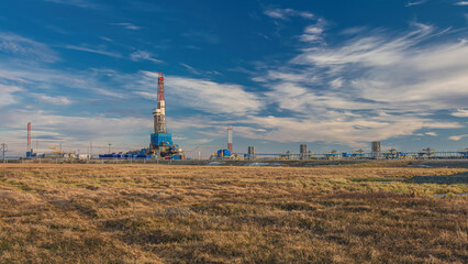 The spring landscape of the Arctic tundra against the background of infrastructure for drilling...