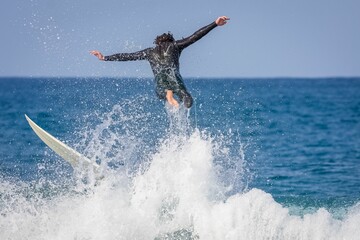Surfer riding a point break waves and being wipeout in Jeffreys Bay, South Africa