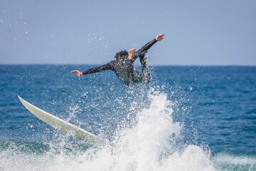 Surfer riding a point break waves and being wipeout in Jeffreys Bay, South Africa - obrazy, fototapety, plakaty