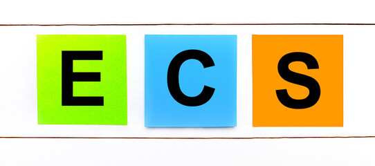 On a white wooden background there are three colorful bright stickers with text ECS Electronic Clearing Service